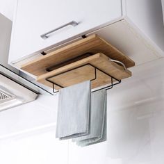 a kitchen hanging from the ceiling with two towels on it's rack and one folded up