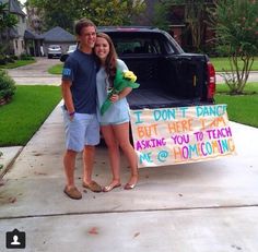 two people standing in front of a truck with a sign on it that says don't dance, but here i am spinning you around and around in circles