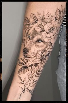 a person with a tattoo on their arm that has flowers and a wolf's head