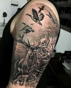 a man with a deer and birds tattoo on his arm