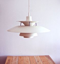 a white light hanging over a wooden table