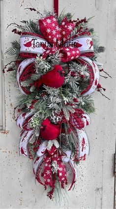 a red and white christmas wreath hanging on a door