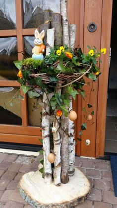 a tree stump with flowers and eggs in it