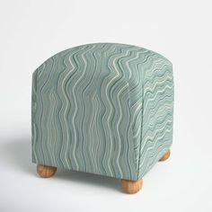 a small stool made out of wood and fabric with wavy design on the top, sitting in front of a white background