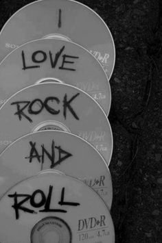 four dvds with graffiti on them sitting in front of a black background and the words love rock and roll written on it