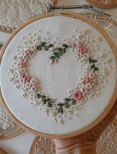 a hand embroidered heart with flowers on it