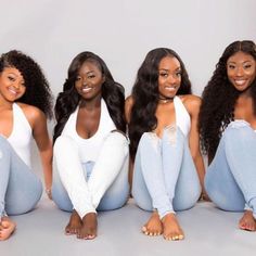 three beautiful women sitting next to each other on the floor wearing jeans and white shirts