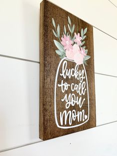 a wooden sign that says lucky to call you mom on it with flowers in a mason jar