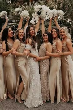 a group of women standing next to each other holding bouquets