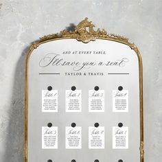 a wedding seating chart on a gold framed mirror