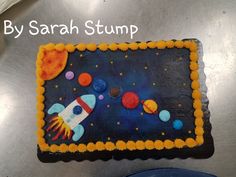 a cake that is shaped like a space shuttle on top of a metal surface with the words by sarah stump written above it