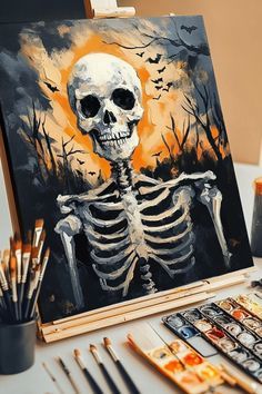 a skeleton painting on an easel next to some paintbrushes and other art supplies