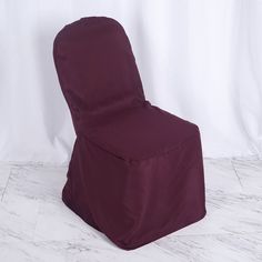 a chair covered in a purple cover sitting on top of a white floor