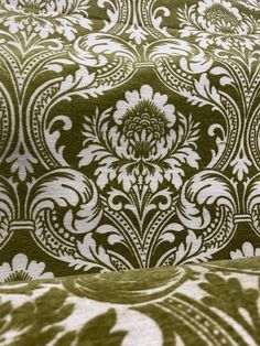 an upholstered green and white fabric with floral designs