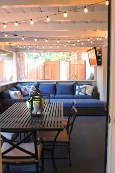 a living room filled with furniture and lots of lights hanging from the ceiling above it