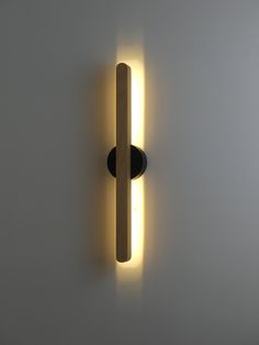 a light that is on the wall next to a white wall with a black handle