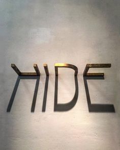 the word idf spelled in gold letters on a white wall with shadow from it