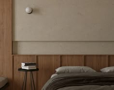 a bed sitting next to a night stand with two books on it's side