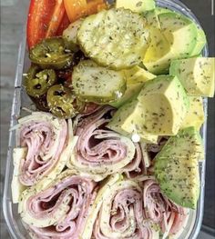 a plastic container filled with lots of different types of vegetables and meats on top of each other