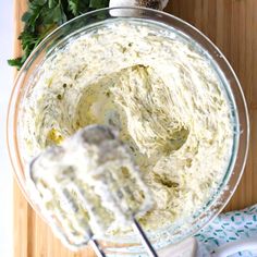 a mixing bowl filled with cream cheese and parsley