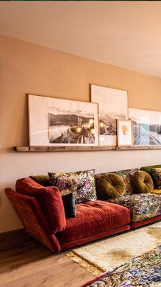 a living room filled with lots of furniture and pictures on the wall above it's couch