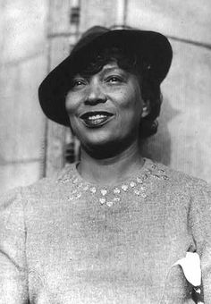 a black and white photo of a woman wearing a hat