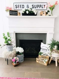 a white fireplace with flowers and plants on the mantel above it is a sign that says seed & supply