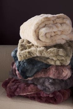 a pile of blankets sitting on top of a couch