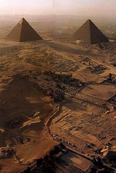 an aerial view of three pyramids in the desert