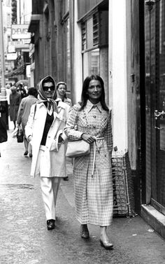 two women walking down the street in an old photo