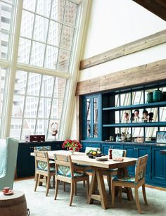 a dining room table and chairs in front of a large window