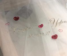 the word love is spelled with hearts and sequins on a white fabric background