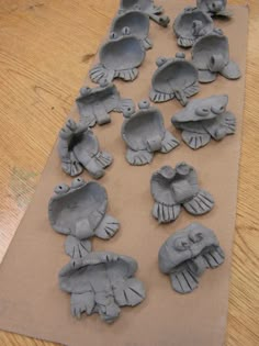 clay fish and turtle molds laid out on a piece of brown paper, ready to be made