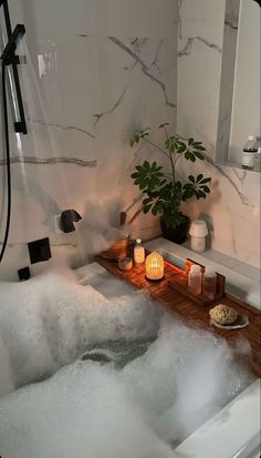 a bathtub filled with foam next to a potted plant