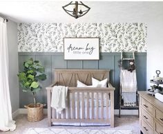 a baby's room with green and white wallpaper