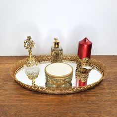 an ornately decorated tray with candles and other decorative items on the top, sitting on a wooden table