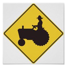 a tractor crossing sign with the silhouette of a farmer on it's front wheel