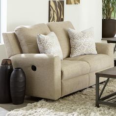 a living room scene with focus on the couch and two vases sitting on the rug