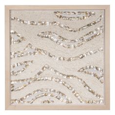 a white and gold wall hanging with sequins on the side, in a wooden frame