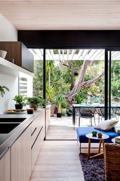 an instagram photo of a kitchen and living room with plants on the counter top