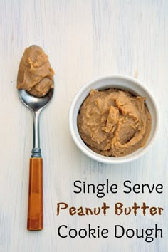 a bowl of peanut butter next to a spoon on top of a white surface with the words single serve peanut butter cookie dough