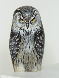 an owl statue sitting on top of a white shelf