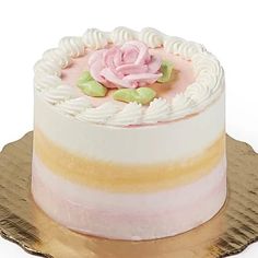 a cake with white frosting and pink icing on a gold plated platter