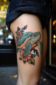 a woman's thigh with a turtle and flowers on it