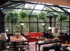 a living room filled with lots of furniture and plants on the windows sills