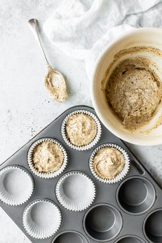 cupcake batter in a muffin tin next to an unwrapped bowl