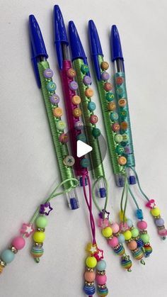 four pens are lined up with beads on them