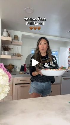 a woman is holding a bowl with food in it