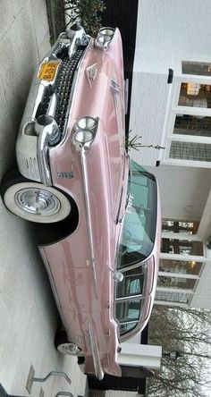 a pink car parked on the side of a building