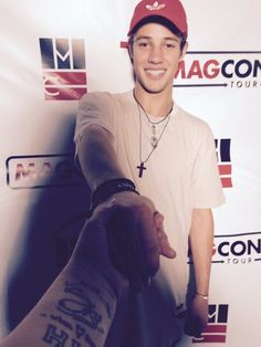 a man in a baseball cap is shaking hands with another man wearing a red hat